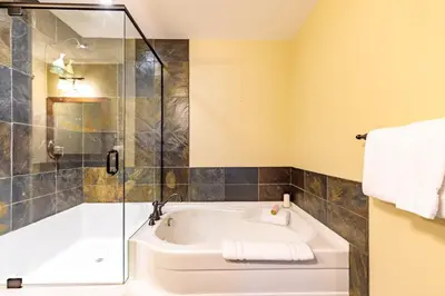 a bathroom with a tub and a glass shower at Spring Creek Serenity at Rundle Cliffs Lodge in Canmore