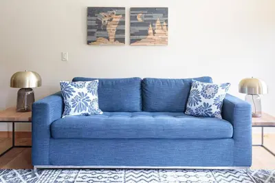 a blue couch in a living room with two lamps at Spring Creek Serenity at Rundle Cliffs Lodge in Canmore