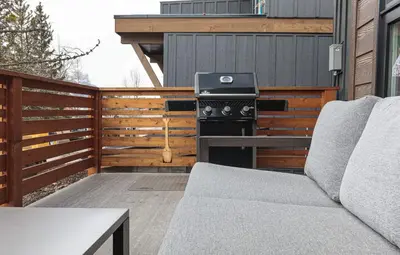 a patio with a grill and a couch on a deck at El Refugio - Private Townhouse with Amazing Views in Canmore