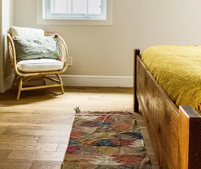 a bedroom with a bed and a chair and a rug at El Refugio - Private Townhouse with Amazing Views in Canmore
