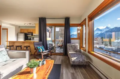 a living room with a couch and a large window at Valhalla - Pure Mountain Bliss in Canmore