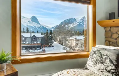 a window with a view of a snow covered mountain at Valhalla - Pure Mountain Bliss in Canmore