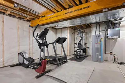 a gym with two treadmills and a machine at Luxe Retreat with Gym, Ping Pong, King Bed, Near WEM in Edmonton