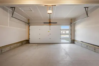 an empty garage with white walls and white garage doors at Luxe Retreat with Gym, Ping Pong, King Bed, Near WEM in Edmonton