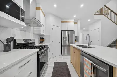 a kitchen with white counters and a stainless steel refrigerator at Spacious 4 Beds Sleeps 8 Near Airport Family Home in Nisku