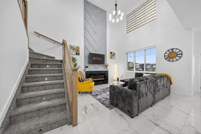 a living room with a staircase and a yellow couch at Spacious 4 Beds Sleeps 8 Near Airport Family Home in Nisku