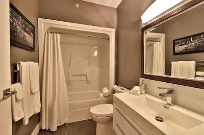 a bathroom with a toilet and a sink and a shower at Ice District 2 Kings Private Parking Patio in Edmonton
