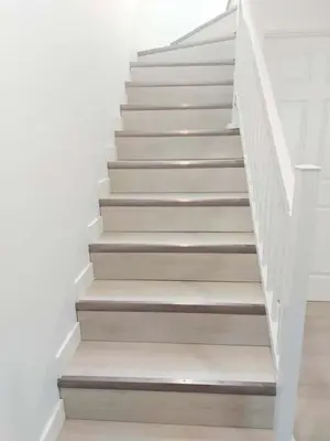 a stairway with white stairs and white walls at 43 Erin Woods Drive SE Calgary in Calgary