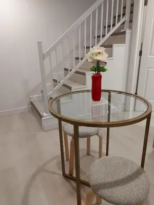 a glass table with a vase with a flower on it at 43 Erin Woods Drive SE Calgary in Calgary