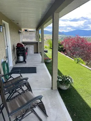 a porch with chairs and a grill on a house at 20 KLM from SilverStar with private Hot Tub in Vernon