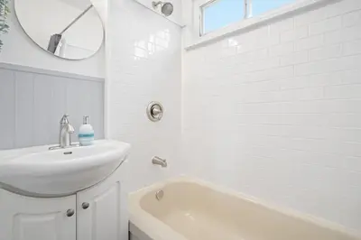 a white bathroom with a sink and a mirror at Blue Raptor Family-Friendly 3BR Private Yard in Drumheller