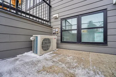 an air conditioner sitting on the side of a house at Deluxe Mahogany Lake Getaway Sleeps 4 in Calgary