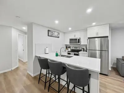 a kitchen with a counter and a refrigerator at Deluxe 2-Bedroom Getaway Near Mahogany Lake in Calgary