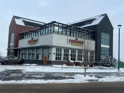 a large building with a parking lot in front of it at Deluxe 2-Bedroom Getaway Near Mahogany Lake in Calgary