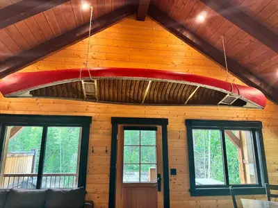 a red surfboard hanging from the ceiling of a room at Explorer Creekside Cabin - Private Hot Tub in Golden