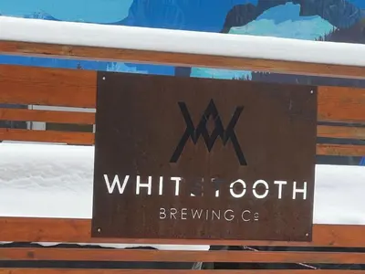 a sign on the back of a bench with the writing whittolith brewing c at Golden Moments in Golden