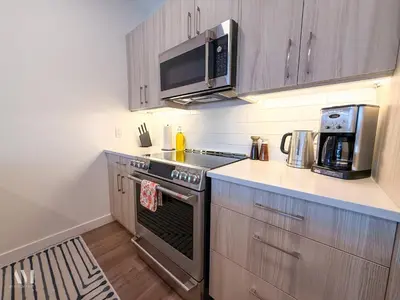 a kitchen with a stove and a microwave at Oso Skyview Suite - DT modern 2 bed, 2 bath in Golden