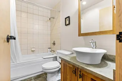 a bathroom with a sink and a toilet and a tub at Whispering Pines 3BR Townhouse Views and private Hot Tub in Golden