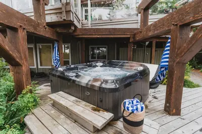 a jacuzzi tub on a wooden deck at Chesterman on the Point - Beachfront in Tofino