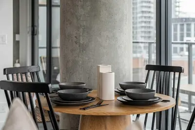 a wooden table with black bowls and plates on it at The Domain Skyline View King Beds Pool Gym in Calgary