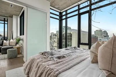 a bedroom with a bed with a view of a city at The Domain Skyline View King Beds Pool Gym in Calgary