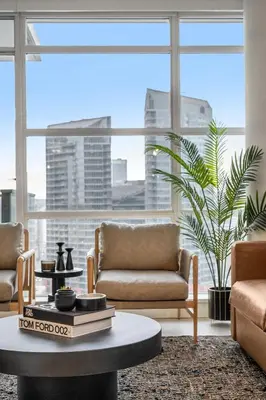 a living room with a coffee table and a large window at Manhattan Right Next to Stampede Grounds DT in Calgary