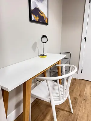 a white desk and a white chair in a room at NorthEdge Suites in Edmonton