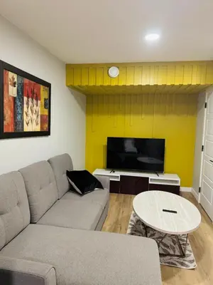 a living room with a couch and a tv at Roj exclusive comfort home in Edmonton