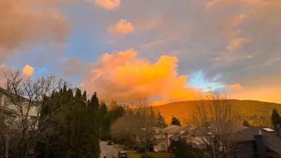 a cloudy sky over a town with houses and trees at Warm house1 in Coquitlam
