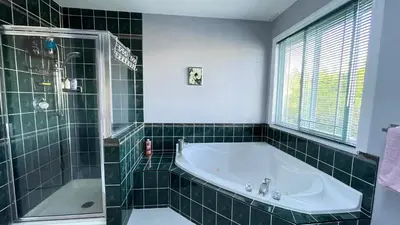 a green tiled bathroom with a tub and a shower at Warm house1 in Coquitlam