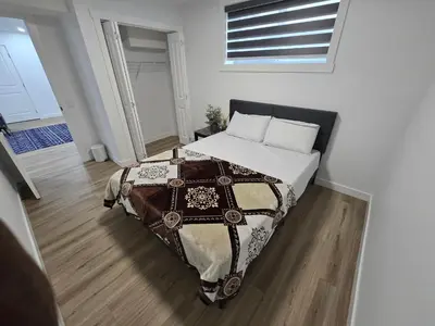a bedroom with a bed with a blanket on it at Clearwater Chestermere in Chestermere