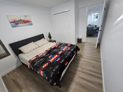 a bedroom with a bed with a superhero blanket on it at Clearwater Chestermere in Chestermere