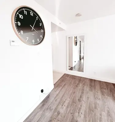 a large clock on a wall in a room at Riverside Mint 2bd den 2 ba in Calgary