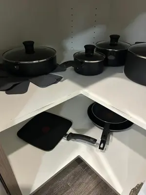 four pots and pans on a shelf in a kitchen at Family friendly home at Chappelle garden in Edmonton