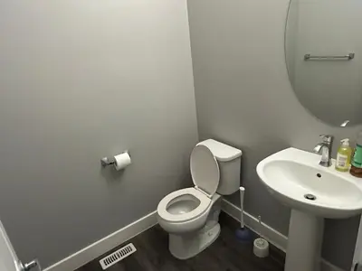 a bathroom with a white toilet and a sink at Family friendly home at Chappelle garden in Edmonton