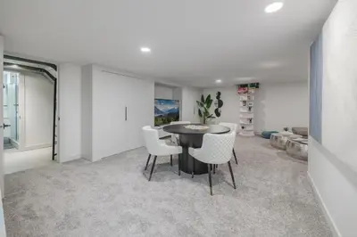 a dining room with a table and white chairs at Board Games, King Bed, Cocoa Bar, & Firewood! in Calgary