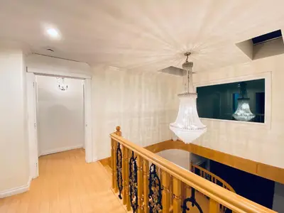 a hallway with a staircase with a chandelier at 5 Minutes away from Edmonds Station! Ideal location for all events & attractions in New Westminster