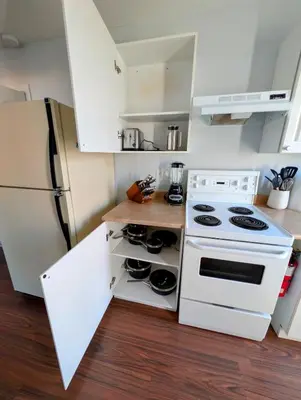 a kitchen with a white stove and a refrigerator at Executive Suite 2 Bedroom Serviced Apartment in Alert Bay