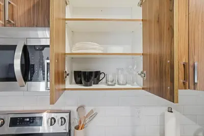 a kitchen cabinet with plates and utensils in it at Luxury 1Beds and 2Beds in Downtown Edmonton close to Rogers in Edmonton