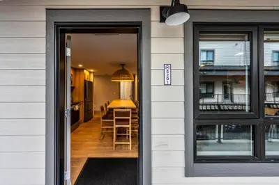 a door leading into a kitchen with a table and chairs at Downtown Revelstoke Retreat by Canadian Rockies Vacation Rentals in Revelstoke