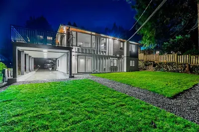 a large house with a green lawn in front of it at Family Home in North Vancouver