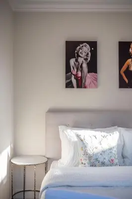 a bedroom with a bed with two pictures on the wall at New Quiet Charming 1BR Suite near UBC & PW Park in Vancouver