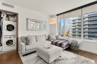 a living room with a couch and a washing machine at Modern Chic Apartment with Balcony & Workspace in Vancouver