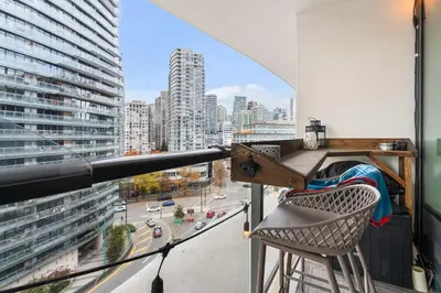 a balcony with a chair and a view of a city at Modern Chic Apartment with Balcony & Workspace in Vancouver