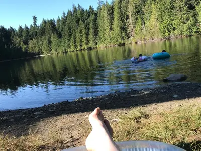 two people in a lake with two people in a raft at Blue Horizon Mountain Retreat B&B in Shawnigan Lake