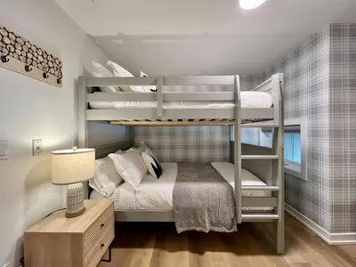 a bedroom with two bunk beds and a desk at Luxury 2 Bedroom Mountain View Condo in Canmore