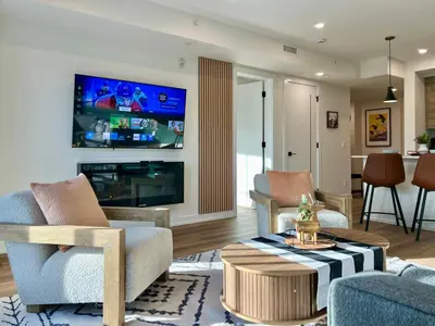 a living room with a fireplace and a tv at Luxury 2 Bedroom Mountain View Condo in Canmore