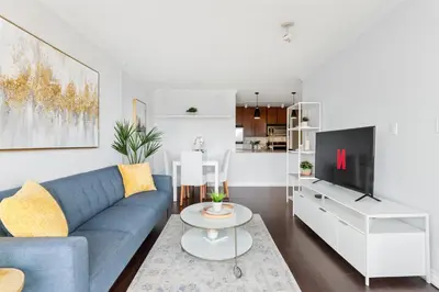 a living room with a blue couch and a tv at Sunny Corner 1-Bedroom Chinatown and Gastown at Your Doorstep in Vancouver