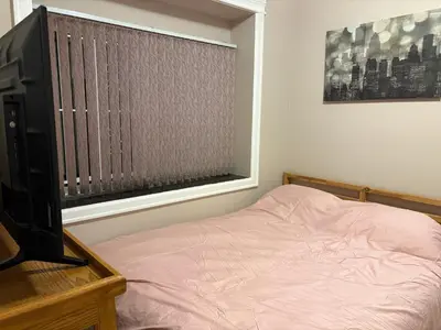a bedroom with a bed and a television and a window at Vacation Home in Vancouver