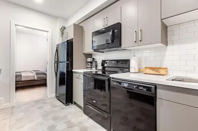 a kitchen with a stove and a microwave at Cozy Suite near West Edmonton Mall & River Cree Casino in Edmonton